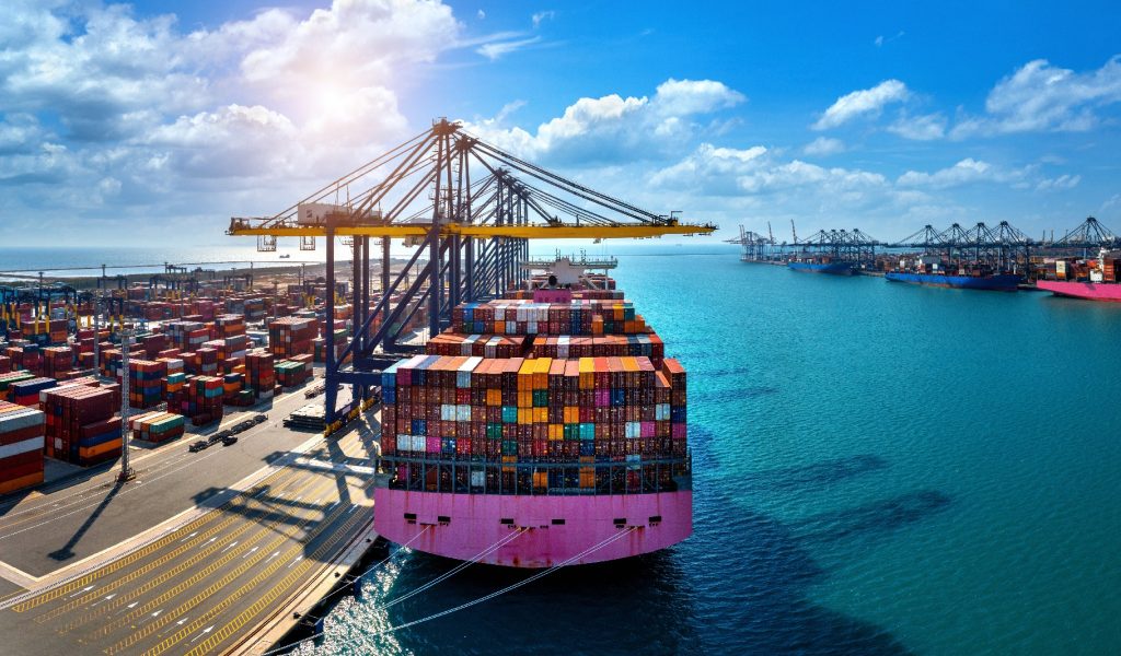 Aerial view of cargo ship and cargo container in harbor.